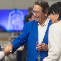 Jim Brooks shaking hands with someone while President Mantella stands nearby